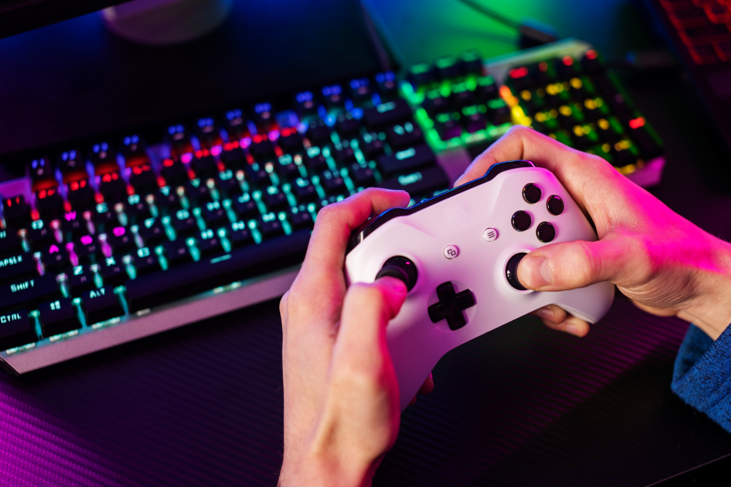 Pessoa jogando em seu computador com um joystick. Ela aprende inglês com jogos