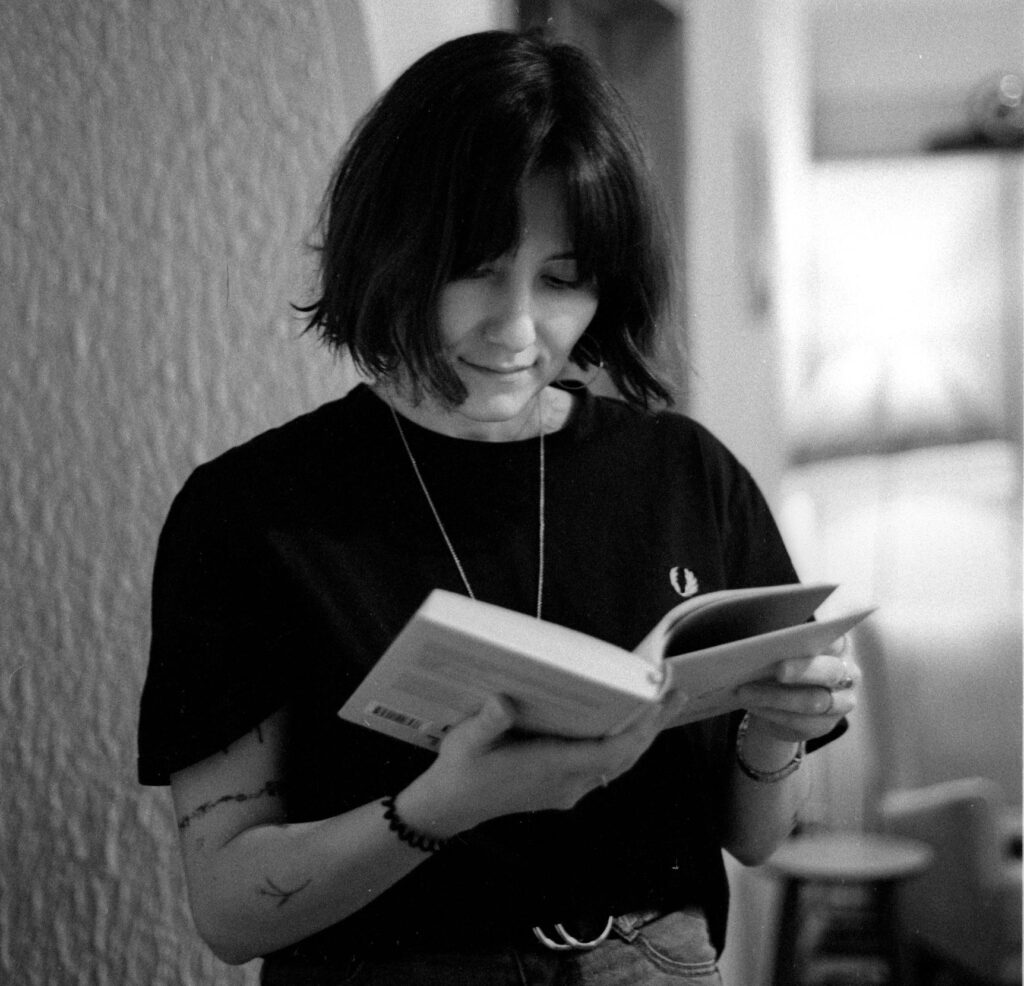 Monochrome portrait of a woman reading a book indoors.