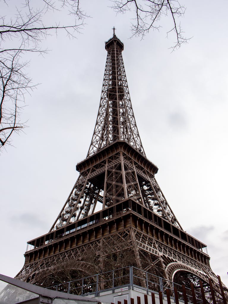 Upward view of Eiffel Tower in Paris, showcasing its iconic architecture.