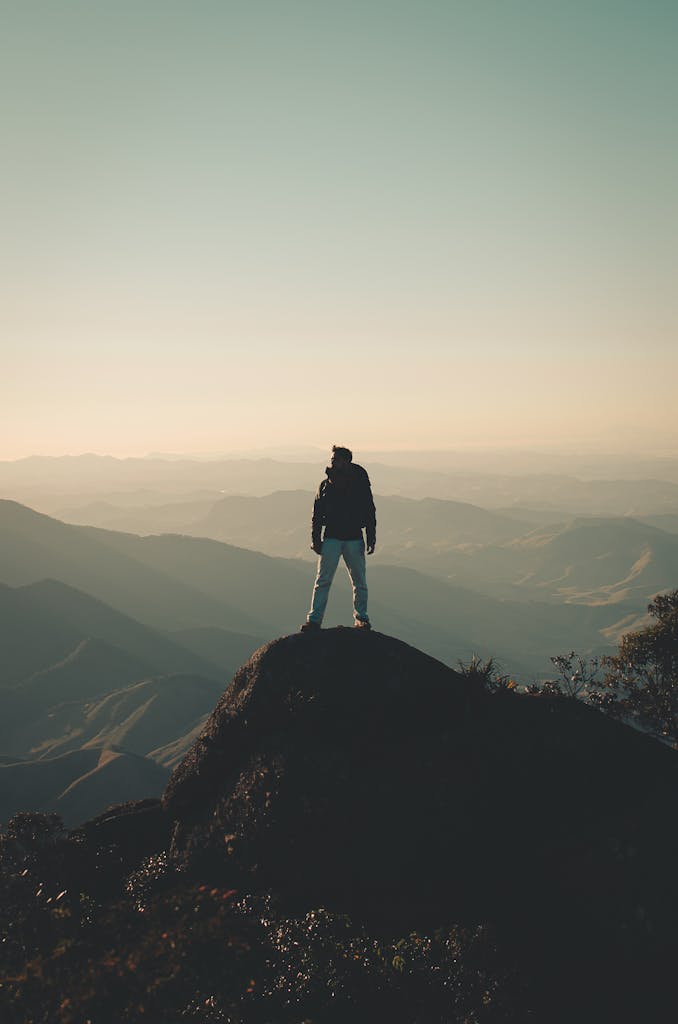 Aplicando-se ao post "Melhore seus estudos - 5 erros para evitar", um homem escala ao topo de uma montanha, e agora esta observando o vista incrível, resultado de colocar em prática o ultimo ponto - não desista!